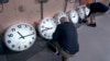 Clockmakers Rich Finn, left, and Tom Erb adjust the time zone controllers on a series of clocks at the Electric Time Company in Medfield, Massachusetts, Oct. 30, 2024.