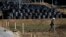 A man walks near waste containing radiated soil, leaves and debris from the decontamination operation at a storage site at Miyakoji area in Tamura, Fukushima prefecture, April 1, 2014. 