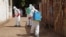 FILE - Health workers spray disinfectant around a mosque in Bamako, Mali, Nov. 14, 2014