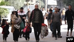 Palestinians walk with their belongings to safer areas in the Nuseirat camp in the central Gaza Strip, on Nov. 28, 2024, amid the ongoing war in the Palestinian territory between Israel and Hamas.