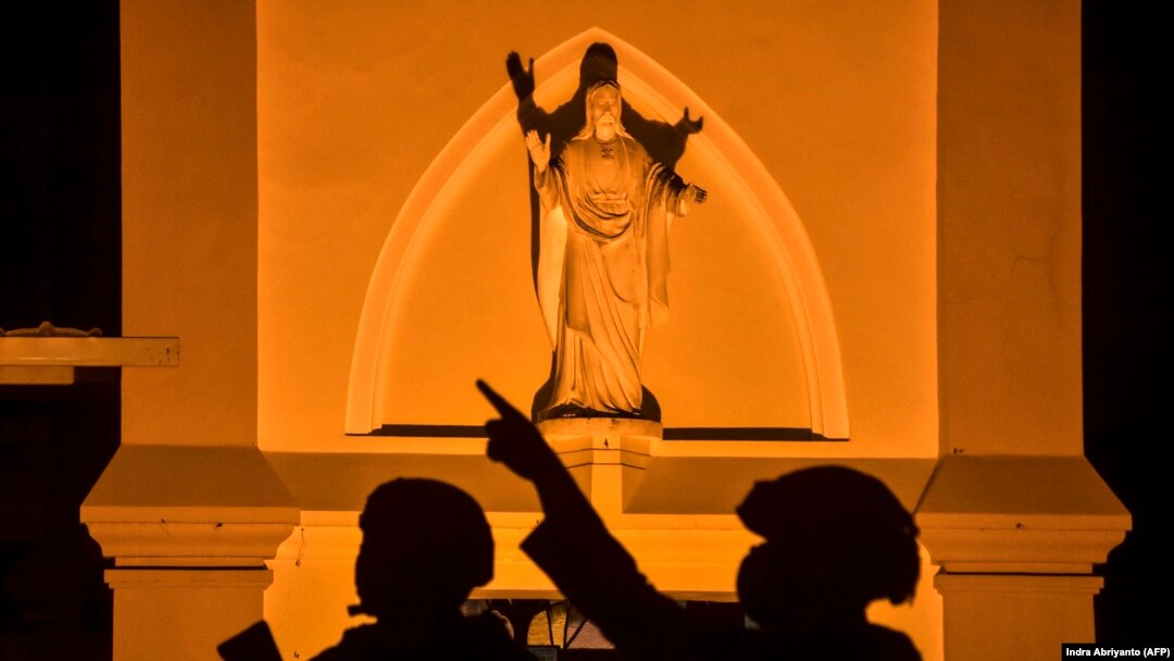Sejumlah polisi berjaga di Katedral Hati Kudus Yesus di Makassar menjelang perayan Paskah menyusul serangan bom bunuh diri di gereja itu pada 28 Maret, Jumat, 1 April 2021. (Foto: Indra Abriyanto/AFP)