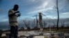 Jeffrey Roberts, un bahameño de 49 años, come mientras revisa los escombros de la casa de familiares destruida por el huracán Dorian, en Pelican Point, Gran Bahama, Bahamas, el sábado 14 de septiembre de 2019.