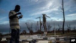 Jeffrey Roberts, un bahameño de 49 años, come mientras revisa los escombros de la casa de familiares destruida por el huracán Dorian, en Pelican Point, Gran Bahama, Bahamas, el sábado 14 de septiembre de 2019.