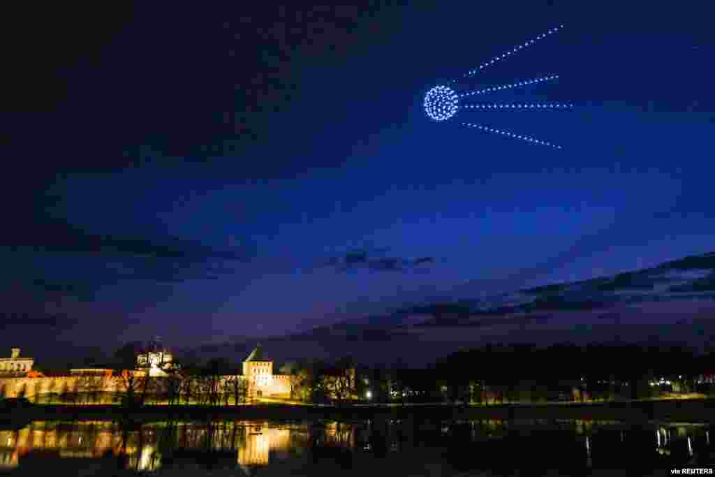 Drones forming a figure of the first artificial Earth satellite &quot;Sputnik 1&quot; light up the evening sky on the eve of Cosmonautics Day in Veliky Novgorod, Russia, April 11, 2021. (Press service of the Government of the Novgorod region/Handout)