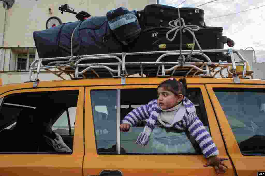 A girl looks out of the window of a vehicle while waiting at the Rafah border crossing's departure area to travel from the Gaza Strip into Egypt, which reopened after Egypt announced to let through incoming traffic until further notice. 