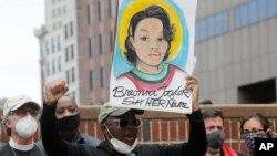 Kevin Peterson, center, founder and executive director of the New Democracy Coalition, displays a placard showing Breonna Taylor as he addresses a rally in Boston, June 9, 2020.