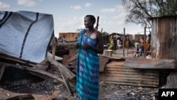 A woman from Murle ethnic group stands at her burnt tea shop in a market in Gumuruk, South Sudan, on June 10, 2021. The village was attacked by an armed youth group. 