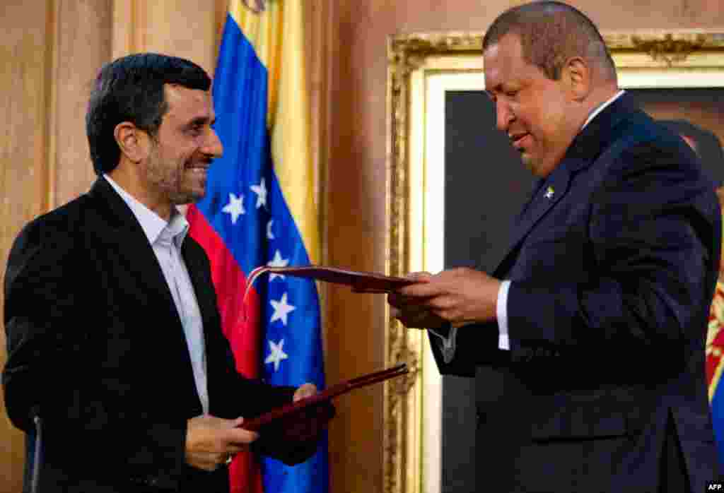 Mr. Ahmadinejad and Mr. Chavez hold up documents after signing agreements at Miraflores presidential palace in Caracas, Venezuela, on January 9, 2012. (AP)