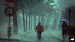 June 23: A man rides his bike during a heavy rain storm in Beijing. Torrential rains in central and southern China threaten the Yangtze River basin and nearby provinces with deadly floods and mudslides. (REUTERS/David Gray)