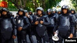 ဂျကာတာမြို့ မြန်မာသံရုံးရှေ့ လုံခြုံရေးစောင့်ကြပ်နေကြတဲ့ အင်ဒိုနီးရှား ရဲတပ်ဖွဲ့ဝင်များ။ (မေလ ၃ ရက်၊ ၂၀၁၃)။