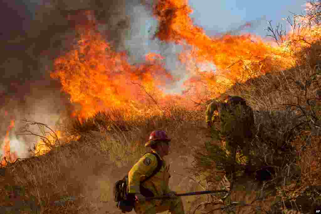 Firefighters battle a wildfire on Cajon Boulevard in Keenbrook, Calif., on Aug. 17, 2016. 