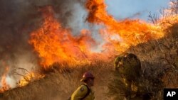 Firefighters battle a wildfire on Cajon Boulevard in Keenbrook, Calif., on Aug. 17, 2016. 