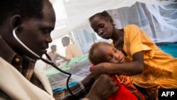 FILE - A doctor examines a young tuberculosis patient who is being held by his mother at the hospital of Doctors Without Borders in Malakal, South Sudan, June 15, 2016.