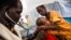 FILE - A doctor examines a young tuberculosis patient who is being held by his mother at the hospital of Doctors Without Borders in Malakal, South Sudan, June 15, 2016.