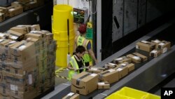 FILE - Packages move down a conveyor system were they are directed to the proper shipping area at the new Amazon Fulfillment Center, Feb. 9, 2018, in Sacramento, Calif. 