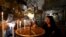 A worshiper lights candles inside the Church of Nativity, ahead of Christmas in the West Bank city of Bethlehem.