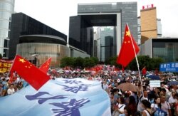 People wave Chinese flags during a pro-China "Safeguard Hong Kong" rally at Tamar Park to voice support for the police and call for an end to violence, in Hong Kong, Aug. 17, 2019.