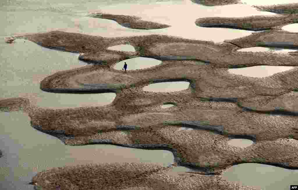 Kinez u hodu plićakom rijeke Hanjiang u centralnoj Kini, čiji je vodostaj uveliko opao usljed dugotrajnih su&scaron;a. 