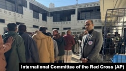 This photo released by the International Committee of the Red Cross shows its officials helping prisoners prepare to be freed by Yemen's Houthi rebels in Sanaa, Yemen, Jan. 25, 2025. 