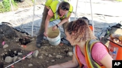 Emma Wink, right, and Stephanie Scialo, part of an archaeological team, work at the site of a 1600's Native American fort in Norwalk, Conn., Aug. 28, 2018.