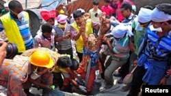 Rescue workers pull a garment worker alive from the rubble of the collapsed Rana Plaza building, in Savar, 30 km outside Dhaka, April 25, 2013.