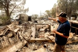 Hank Hanson, 81, gestures to the kitchen of his home, destroyed by wildfire, in Vacaville, California, Aug. 21, 2020.