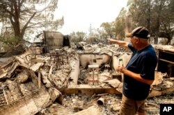 Hank Hanson, 81, gestures to the kitchen of his home, destroyed by wildfire, in Vacaville, California, Aug. 21, 2020.