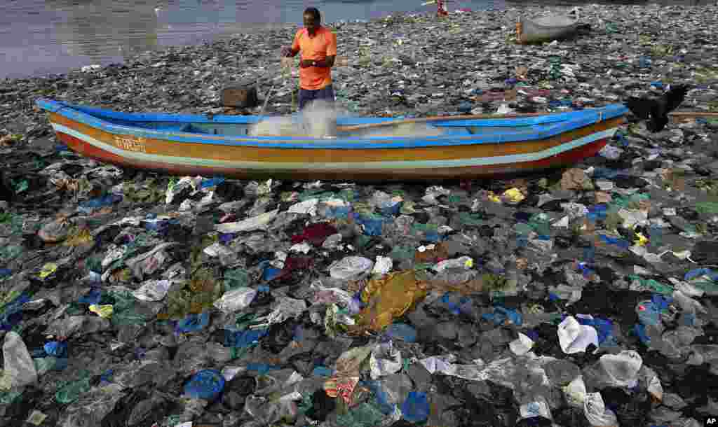 A fisherman prepares his net on the shores of the Arabian Sea, littered with plastic bags, in Mumbai, India.