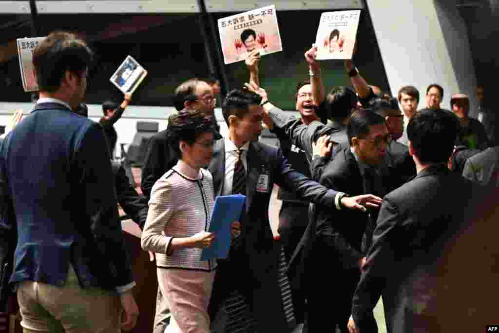 Hong Kong&#39;s Chief Executive Carrie Lam (2nd L) leaves the chamber for a second time while trying to give her annual policy address as she is heckled by pro-democracy lawmakers at the Legislative Council.