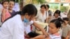 A Cambodian pregnant woman, front right, receives vaccination of A/H1N1 influenza, or swine flu, from the public health service in Phnom Penh, Cambodia, Thursday, April 1, 2010. Cambodia started its first vaccination campaign against swine flu in a series of four phases in four provinces including Cambodia's capital of Phnom Penh, said Cambodian health officers. (AP Photo/Heng Sinith)