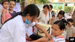 A Cambodian pregnant woman, front right, receives vaccination of A/H1N1 influenza, or swine flu, from the public health service in Phnom Penh, Cambodia, Thursday, April 1, 2010. Cambodia started its first vaccination campaign against swine flu in a series of four phases in four provinces including Cambodia's capital of Phnom Penh, said Cambodian health officers. (AP Photo/Heng Sinith)