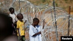 Internally displaced boys stand next to barbed wire inside a United Nations Mission in South Sudan (UNMISS) compound in Juba, Dec. 19, 2013. 