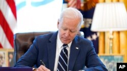 PresidenJoe Biden menandatangani Rencana Penyelamatan AS atau paket bantuan untuk menangani imbas pandemi COVID-19, di Oval Office, Gedung Putih, 11 Maret 2021. 