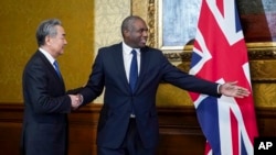 British Foreign Secretary David Lammy, right, welcomes Chinese Foreign Minister Wang Yi ahead of a meeting in London, Feb. 13, 2025.