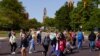 FILE - Masked students cross an intersection on the campus of Ball State University in Muncie, Ind., Sept. 10, 2020. 