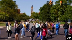 FILE - Masked students cross an intersection on the campus of Ball State University in Muncie, Ind., Sept. 10, 2020. 