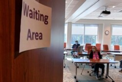 FILE - A woman waits 15 minutes inside the Cherokee Indian Hospital in Cherokee, N.C., after receiving her COVID-19 vaccination as providers monitor patients for negative reactions, Jan. 28, 2021.