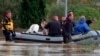 Rescue workers pulling a boat wade on a flooded street at San Gavino Monreale, Sardinia, Italy, Nov. 18, 2013.