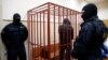 FILE - A defendant stands inside a special cage as he attends a court hearing in Sakhalin, Russia, March 4, 2015. The number of people imprisoned in Russia on extremism-related charges jumped from 137 in 2011 to 414 in 2015, according to independent research.