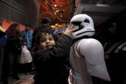 FILE - A child grabs a "Star Wars" toy at the Toys "R" Us Times Square store in the Manhattan borough of New York, Nov. 26, 2015.