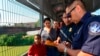 ARCHIVO - Agentes de la Patrulla Fronteriza y Aduanas de EE. UU. procesan a una familia cubana, cuyo turno había sido llamado para cruzar a EE. UU. y solicitar asilo, en un puente internacional entre Nuevo Laredo, México, y Laredo, Texas, el 10 de julio de 2019.