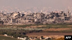 Со стороны израильских позиций на границе с сектором Газа видны разрушенные в результате израильских бомбардировок здания