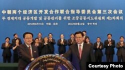 14일 베이징에서 경제 개발 협력에 합의한 후 악수하는 장성택 북한 국방위원회 부위원장(왼쪽)과 천더밍 중국 상무부장. 중국 상무부 웹사이트.