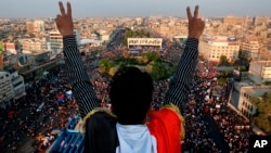 Seorang pengunjuk rasa anti-pemerintah mengacungkan tanda kemenangan di hadapan massa yang berkumpul di Lapangan Tahrir di Baghdad, Irak, 31 Oktober 2019. 