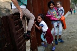 Una niña migrante llora junto al muro fronterizo cuando intenta cruzar con su familia desde Tijuana, México,en diciembre de 2018.