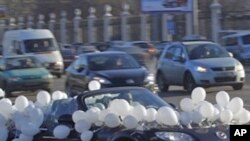 A car decorated of white balloons seen on the Moscow's Garden Ring road during a protest in Moscow, Russia, Sunday, Jan. 29, 2012. Hundreds of cars flying white ribbons or white balloons are driving around Moscow's Garden Ring in a show of support for a p