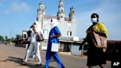 FILE - Health workers arrive to administer cervical cancer vaccine HPV Gardasil to young girls on the street in Ibadan, Nigeria, May 27, 2024. The World Health Organization estimates that 80% of childhood cancers occur in low-income countries like Nigeria,