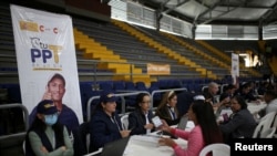 ARCHIVO - Empleados de Migración Colombia trabajan durante un día de entregas de Permiso de Protección Temporal (PPT) organizado por Migración Colombia en el Palacio de los Deportes en Bogotá, Colombia, 1 de septiembre de 2023. 