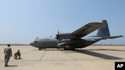 Un soldat américain regarde un avion US Air Force transportant des armes et des équipements arrivent à l'aéroport international Rafik Hariri à Beyrouth, au Liban, le 29 août 2014.