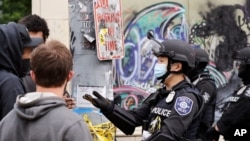 A police officer engages with a protester July 1, 2020, in Seattle, where streets had been blocked off in an area demonstrators had occupied for weeks.